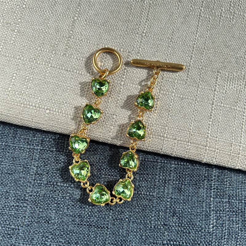 Green crystal heart link bracelet with gold-tone chain and heart-shaped stones