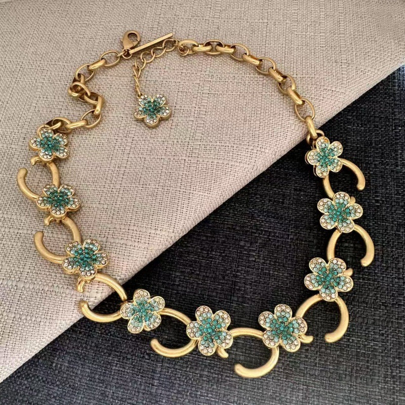 Gold-tone O-ring floral necklace with turquoise flower clusters and crystal detailing