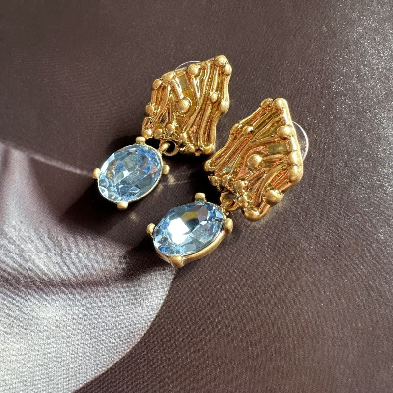 Blue crystal drop earrings with gold-tone textured caps
