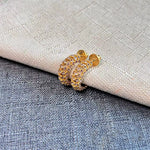 Gold-tone cubic zirconia C-hoop earrings with warm-toned stones; stud backs visible