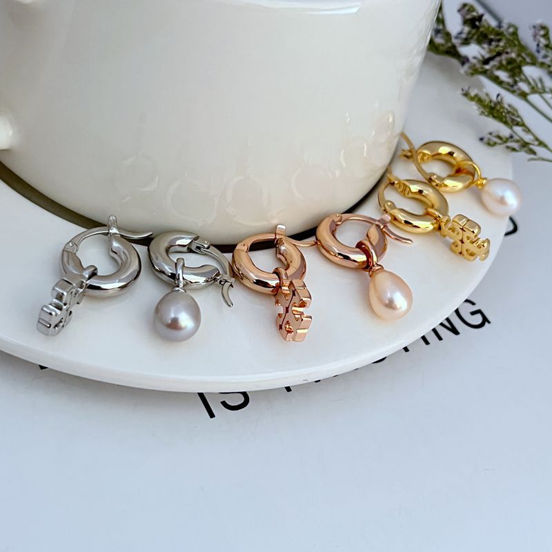 Asymmetrical pearl earrings set in mixed metal tones with pearl drops