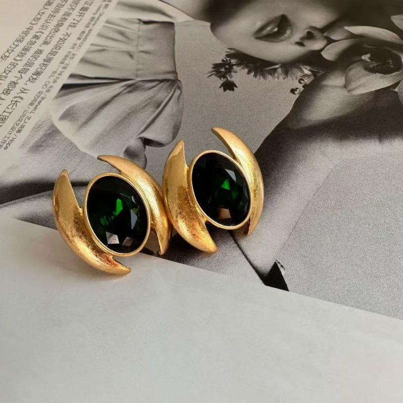 Emerald oval crystal stud earrings with gold curved crescent setting and secure post.