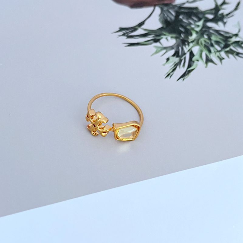 Logo acrylic matte metal ring with translucent green stone, gold-tone band