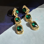 Emerald green crystal long drop clip-on earrings with three oval stones in gold-tone frames