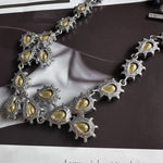 Silver-tone crystal necklace with oval cutouts and gold-toned insets on link chain