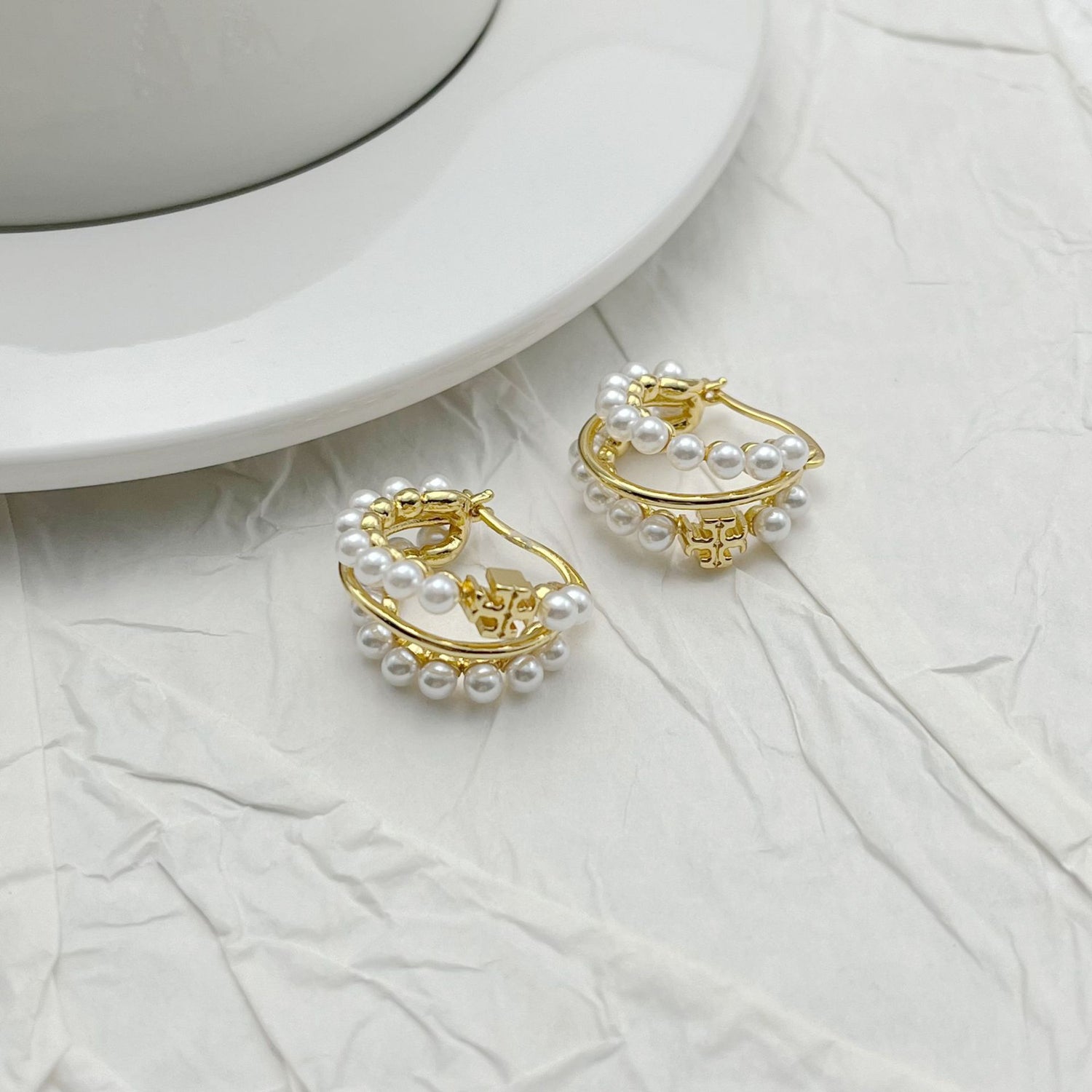 Gold and faux pearl multi-hoop earrings with scalloped outer ring.