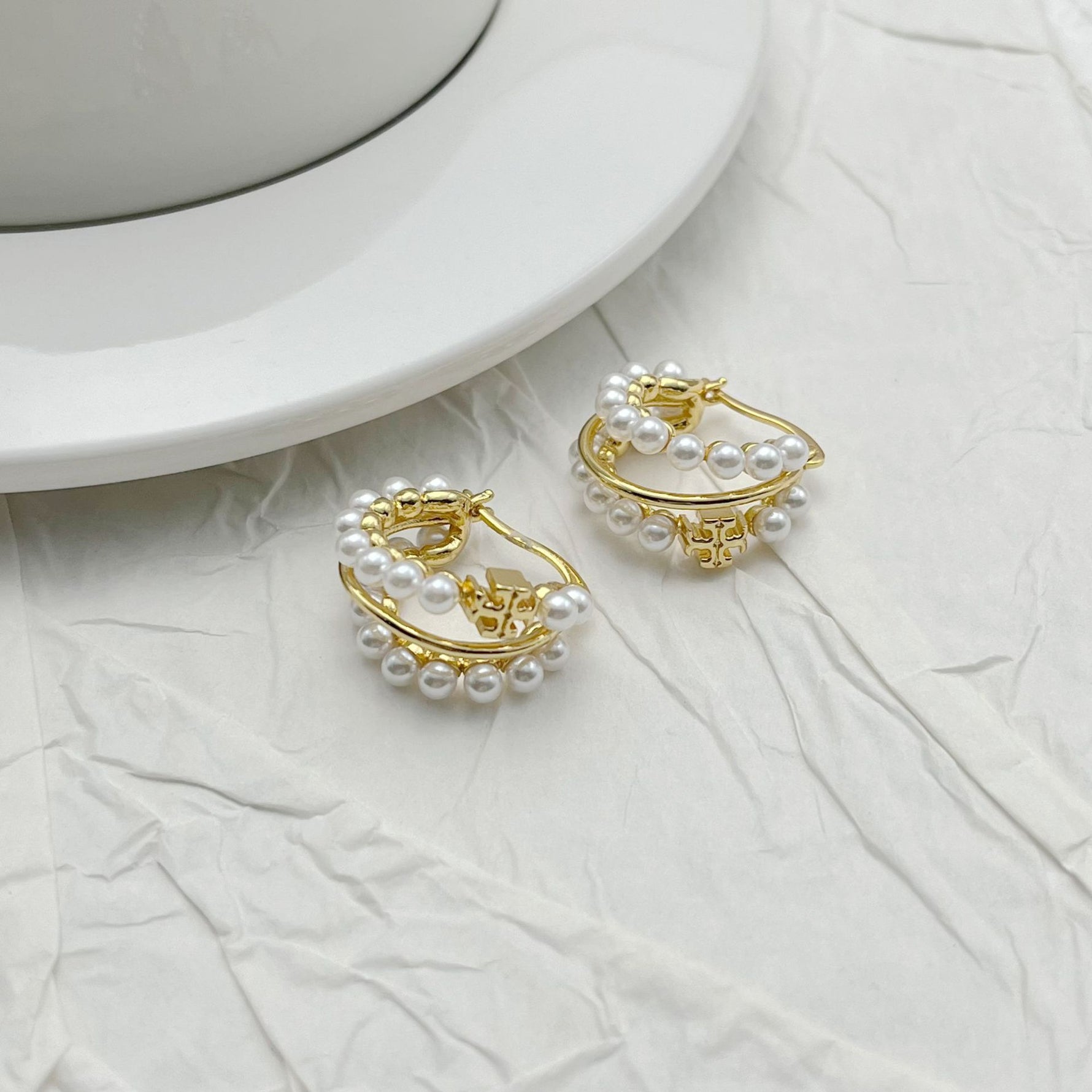 Gold-tone layered hoop earrings with rows of faux pearl beads
