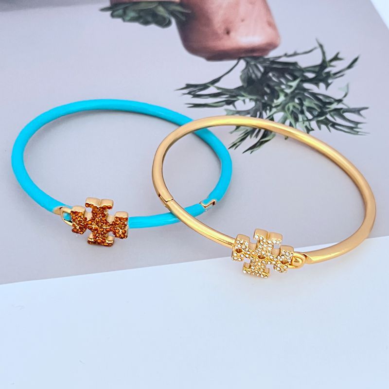 Blue and gold openable bangles with jeweled cross charms and turquoise enamel.