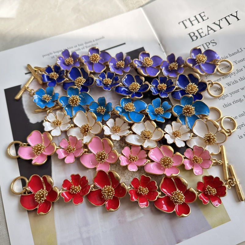 Enamel floral bracelet with blue, white, pink, and red flower charms and gold links
