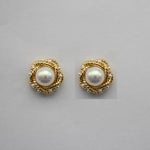 Gold-tone round pearl stud earrings with braided halo and white-luster center pearl