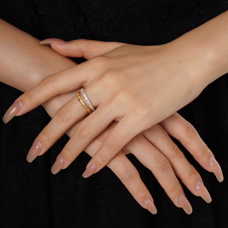 Gold-tone open ring with textured band, worn on hand
