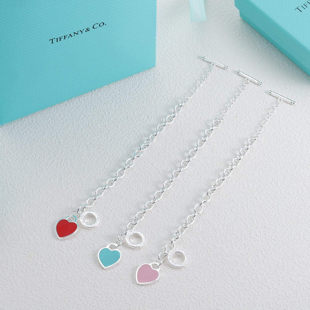 Set of three silver bracelets with red, blue, and pink heart charms