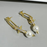 Gold-tone earrings with white pearls and glitter bar plus ribbon bow tips