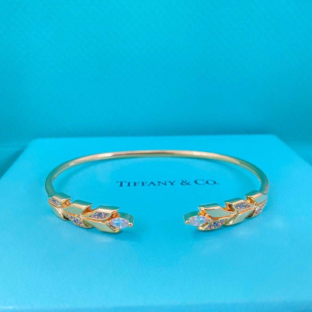 Gold-tone open diamond leaf open bangle, side view
