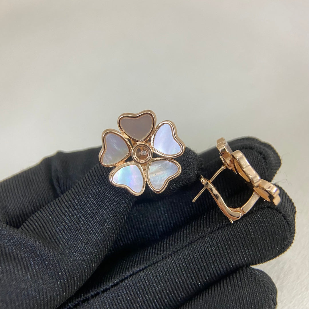 White five-heart stud earrings with gold-tone posts and mother-of-pearl petals