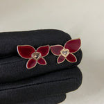 Butterfly enamel earrings with red petals, heart center charm, and gold-tone prongs