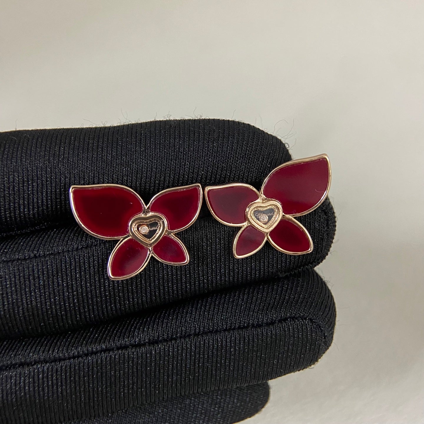 Butterfly enamel earrings with red petals, heart center charm, and gold-tone prongs