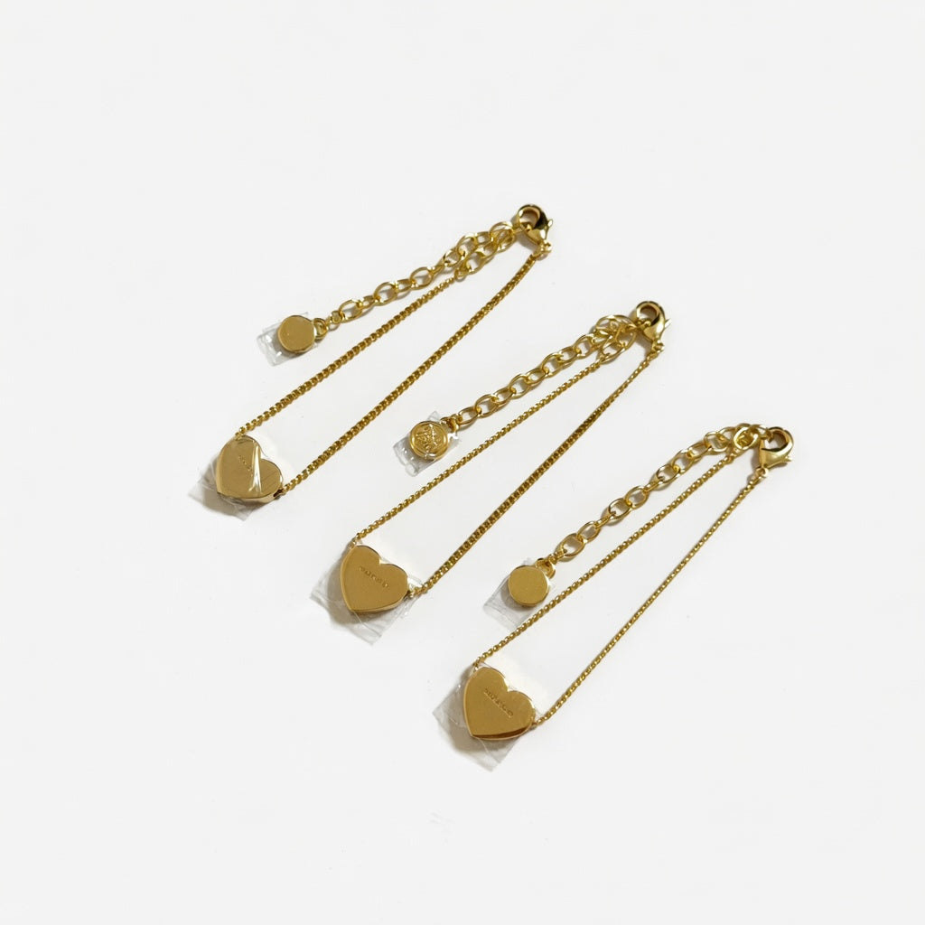 Set of four gold-tone chain bracelets with enamel heart charms and clasps