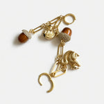 Gold-tone drop earrings with long chains, squirrel charms, and textured brown pinecone tassels