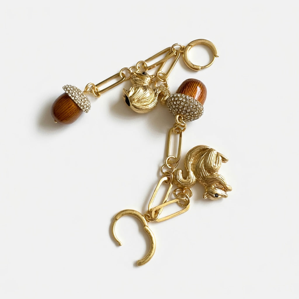 Gold-tone drop earrings with long chains, squirrel charms, and textured brown pinecone tassels