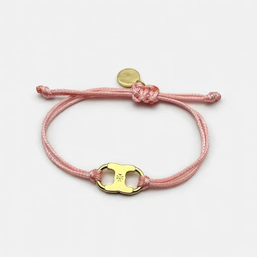Woven enamel bracelet with pink braided cord and gold logo charm with enamel center.