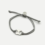 Woven enamel bracelet with gray braided cord and silver logo charm with enamel center.