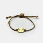 Woven enamel bracelet with brown braided cord and gold logo charm with enamel center.