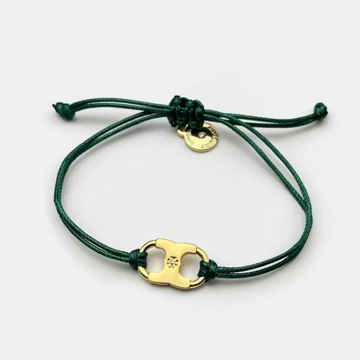 Adjustable drawstring bracelet with gold enamel toggle charm on dark green cords