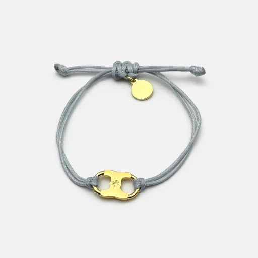 Adjustable drawstring bracelet with gold enamel toggle charm on gray cords
