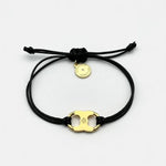 Adjustable drawstring bracelet with gold enamel toggle charm on black double cords