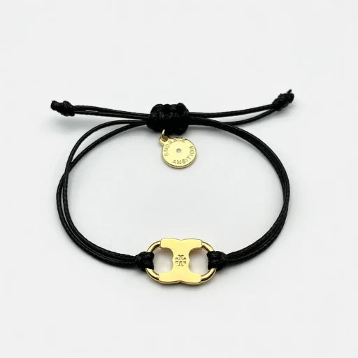Adjustable drawstring bracelet with gold enamel toggle charm on black double cords