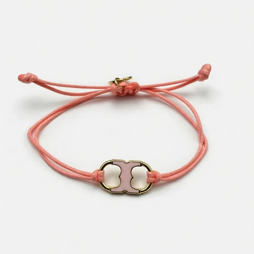 Adjustable drawstring bracelet with pink enamel toggle charm on coral double cords