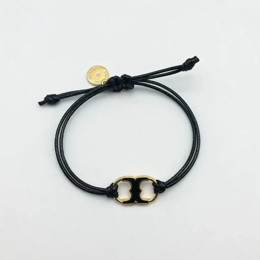 Adjustable drawstring bracelet with gold enamel toggle charm on black cords