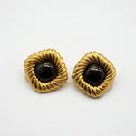 Gold-tone scalloped stud earrings with black cabochon centers, pair