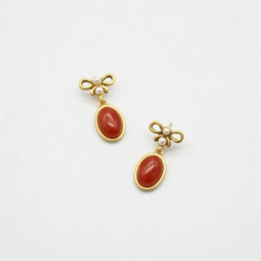 Vintage red oval glass stud earrings with gold bow top and small pearl accents