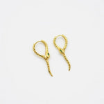Gold-tone snake ear cuffs with green crystal accents and curved dangling ends