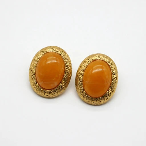 Pair of gold-tone oval stud earrings with glossy yellow glass cabochon and textured rim