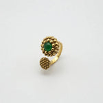 Gold-tone textured ring with oval green stone, raised bubble setting