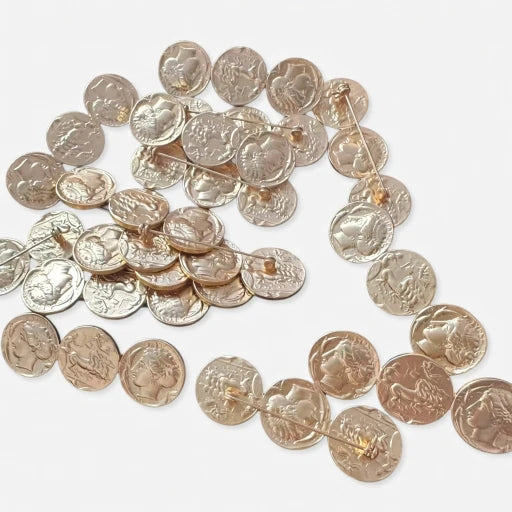 Distressed silver coin brooch with many round engraved discs in a curved layout
