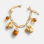 Gold-tone charm bracelet with squirrel, pinecone, acorn and pearl-style beads