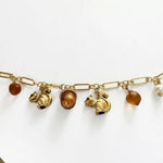 Gold-tone chain bracelet with squirrel and pinecone enamel charms and linked accents