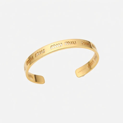 Miu Miu gold-tone open cuff bangle with shiny engraved logo lettering