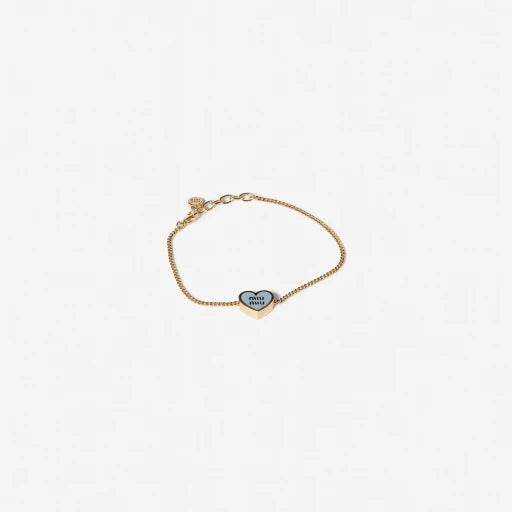 Gold-tone adjustable chain bracelet with dark enamel oval and heart charm