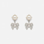 Silver-tone pearl drop earrings with crystal bow and small sparkle dangling details.