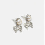 Silver-tone bow stud earrings with white pearl and crystal bow charms.