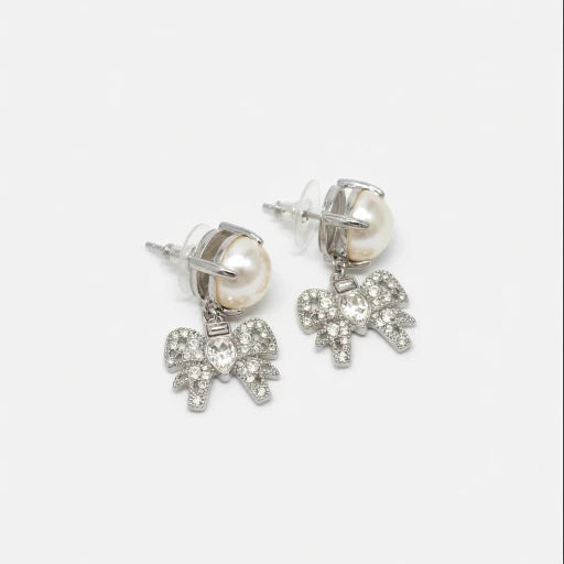 Silver-tone bow stud earrings with white pearl and crystal bow charms.