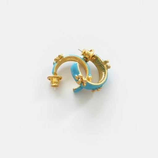 Blue enamel C-shaped hoop earrings with gold-tone embossed flower accents