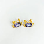 Crab-shaped crystal stud earrings with gold-tone settings, pearls, and a purple gem