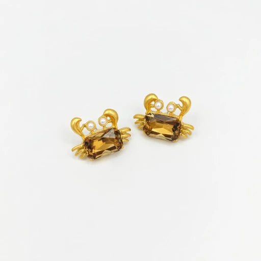 Crab-shaped crystal stud earrings with gold-tone settings, pearls, and a brown gem