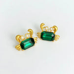Crab-shaped crystal stud earrings with gold-tone settings, pearls, and a deep green gem